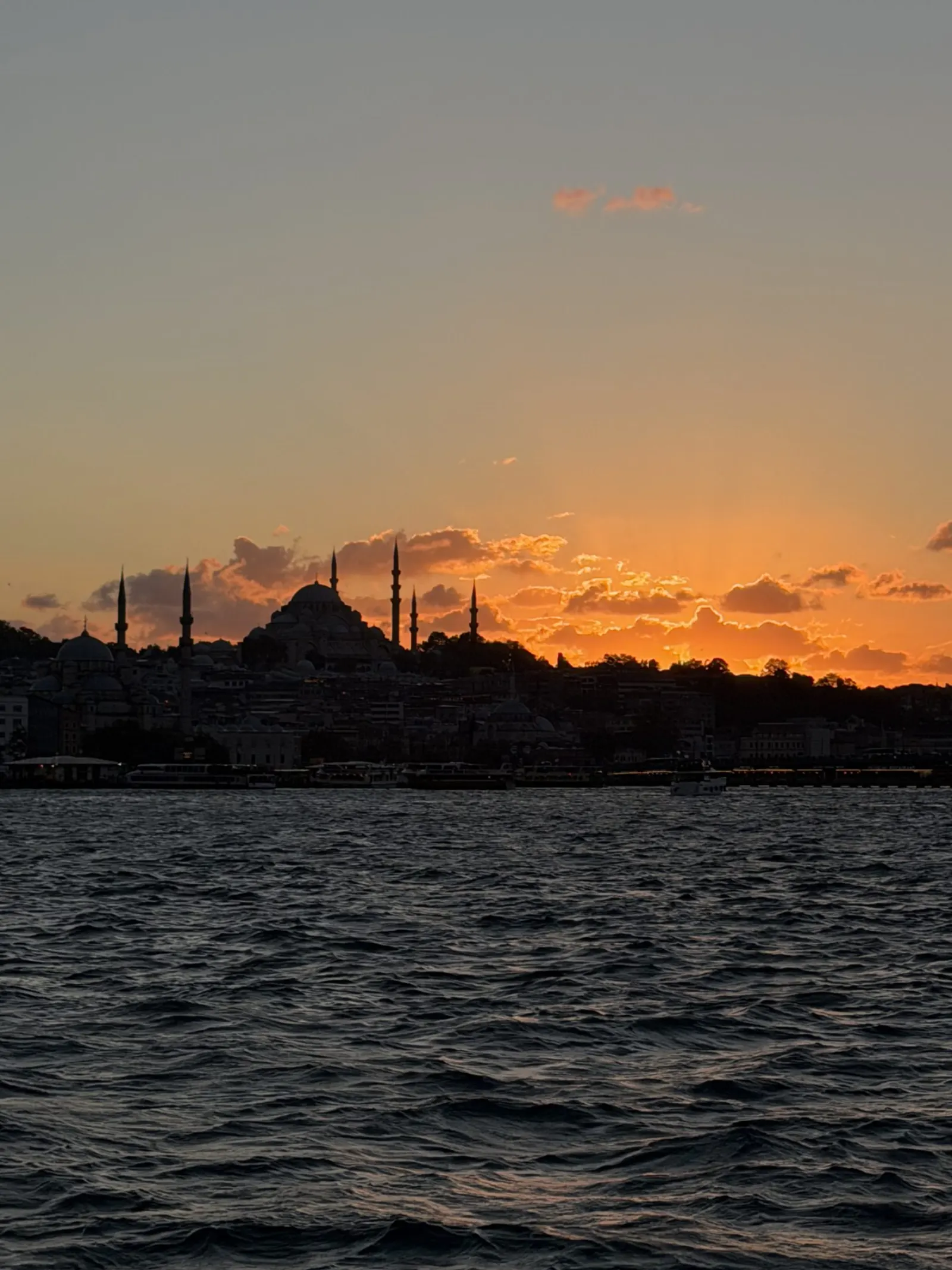 Afternoon Bosphorus cruise boat passing Rumeli Fortress in warm midday light